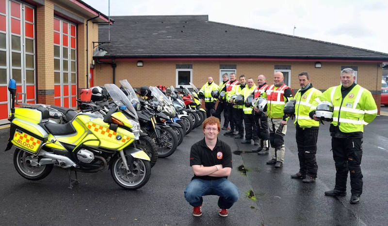 Group of blood bikers with liveried and non-liveried bikes at fire station.